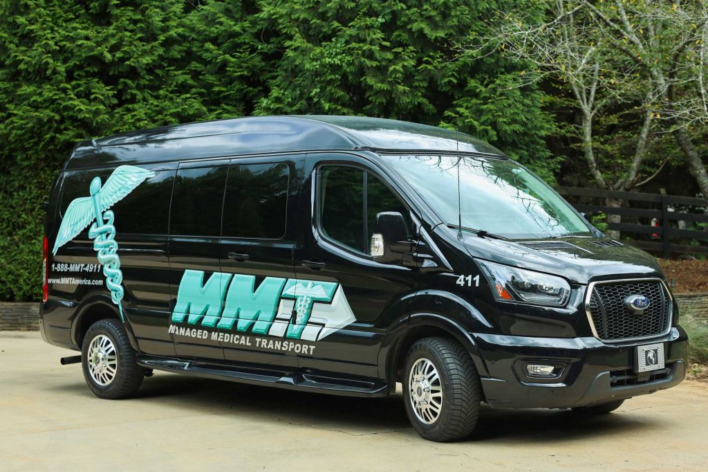 Black medical transport van with logo and contact information.